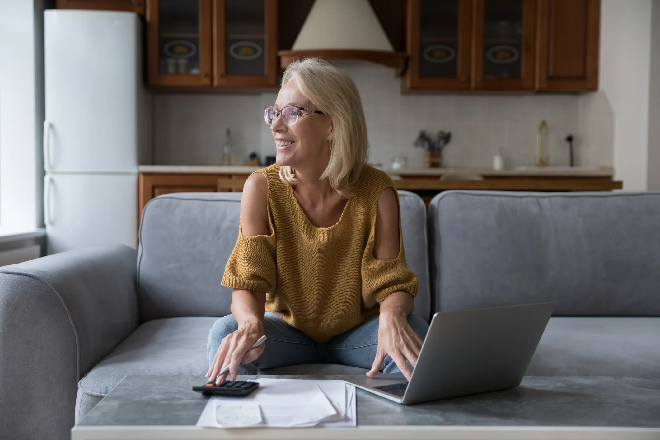 Older white woman doing her bookkeeping on a laptop