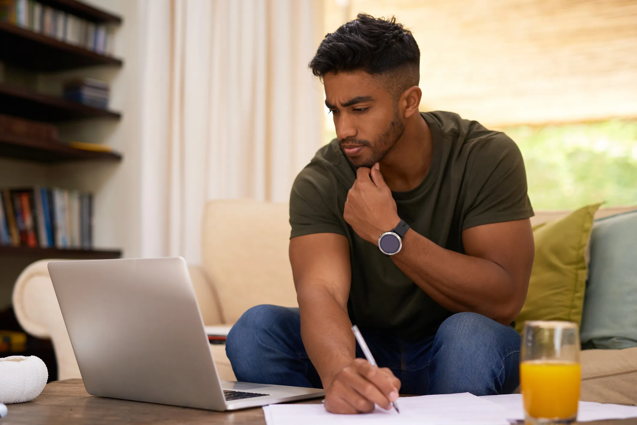 Man looking at computer and filling out form