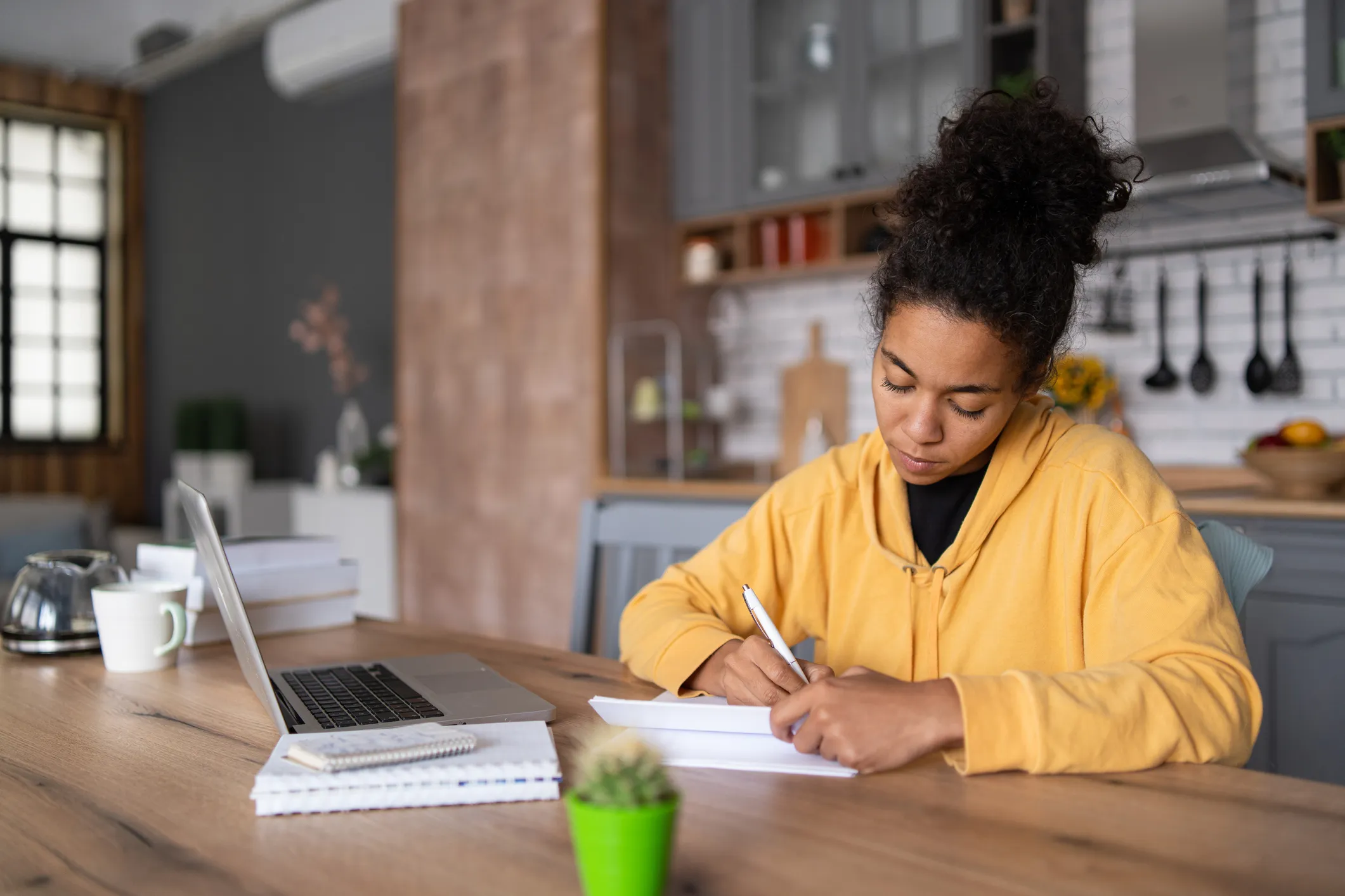Woman at kitchen table writing notes